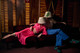Couple lying on a sofa in the Rivoli Ballroom wearing Carnival lampshades on their heads. Photographed by Sophia Spring for the ClothShop marketing campaign for Christopher Farr Cloth. Set in an art deco, retro interior with vintage-inspired styling.